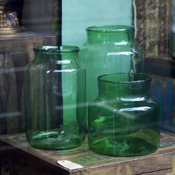 Im Schaufenster stehen große grüne Glasdosen, die als Vasen verwendet werden können — Stockfoto