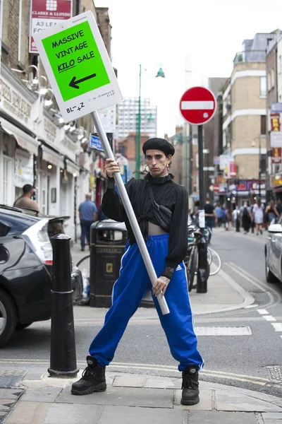 Male promoter with an advertising poster stands in the middle of the pavement on Bricklane — Stock Photo, Image