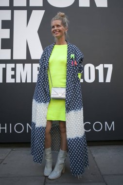 Yeşil kısa elbise ve Londra Moda Haftası sırasında poz bir uzun mavi-beyaz hırka kız. Dış Eudon Choi
