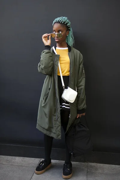 Όμορφη και κομψή γυναίκα στο πράσινο παλτό και κίτρινο t-shirt που παρουσιάζουν κατά τη διάρκεια της εβδομάδας μόδας του Λονδίνου. — Φωτογραφία Αρχείου