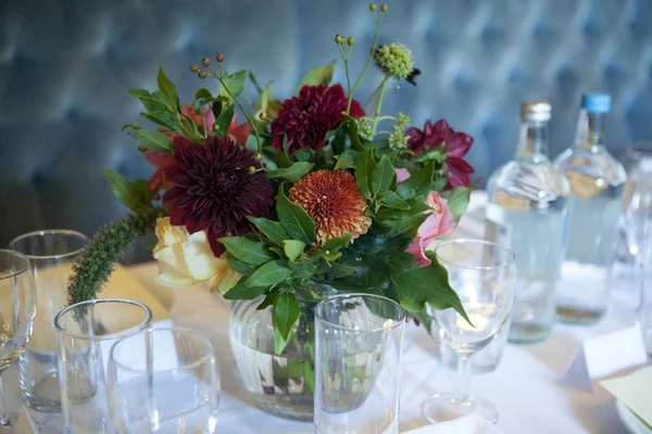 Bröllop bukett av en brud från Dahlia och rosor pryder en bröllops bord i en restaurang — Stockfoto