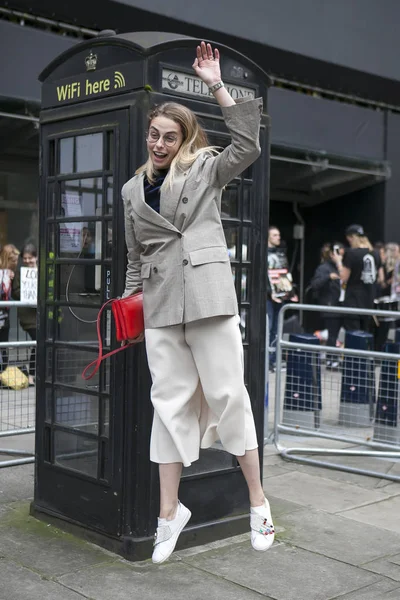 Klasik damalı elbiseli kız telefon kulübesinin önünde atlar