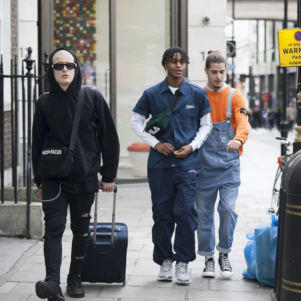 Fashionably dressed teenagers with dreadlocks walking down the street — Stock Photo, Image