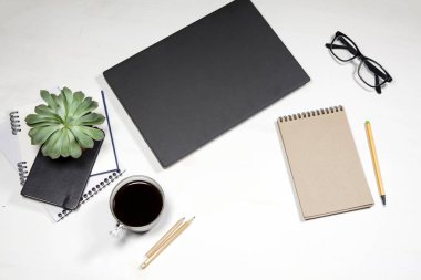 Beyaz ofis masaüstü laptop klavye, bitki, kahve fincanı, gözlük ve Kırtasiye ile üstten görünüm. Yukarı alay