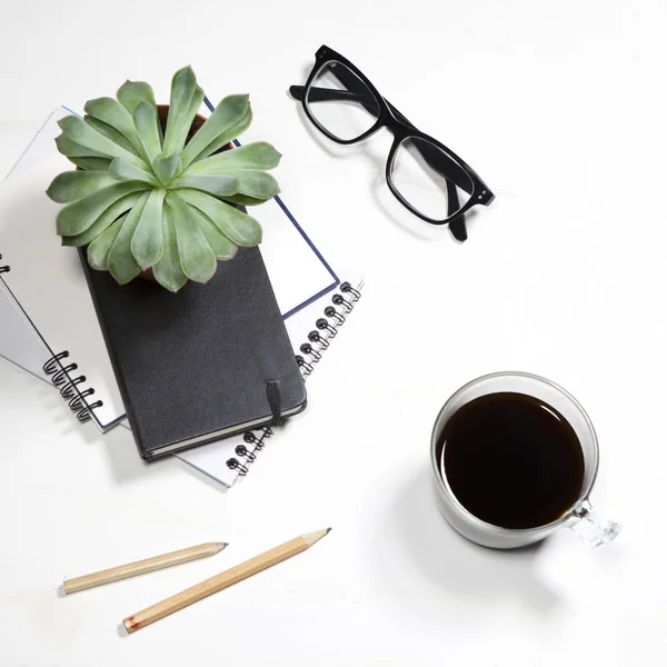 Topp med utsikt över vita office desktop med växt, kaffekopp, Glasögon och kontorsmaterial. Håna upp — Stockfoto