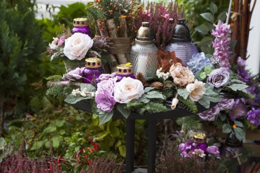 Yapay ve canlı çiçekler, mumlar mor tonlarda Varşova Ölülerin günü tarafından