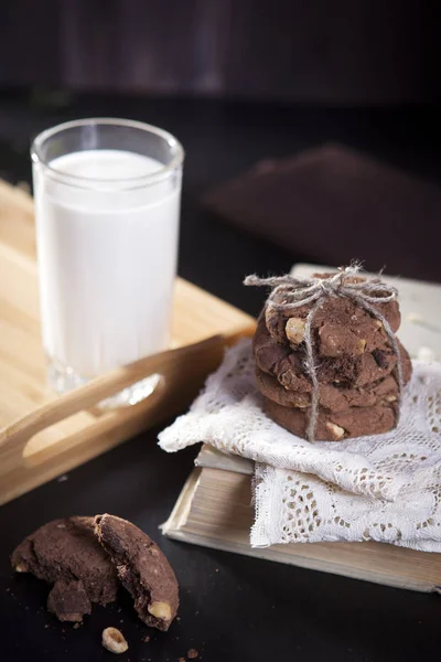 Die Kekse aus dunkler Schokolade mit Nüssen auf dunklem Holzgrund — Stockfoto