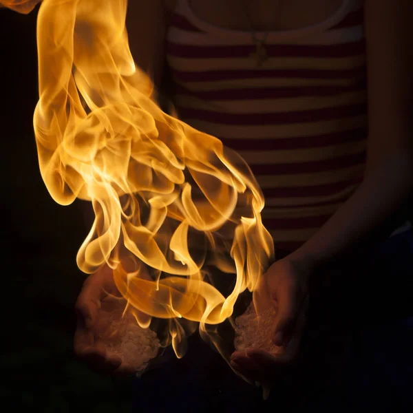 Un feu brûlant dans la paume d'un magicien, contre un noir backgro — Photo