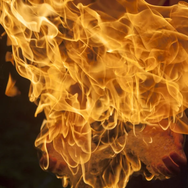 Fogo ardente na palma da mão de um mágico, contra um backgro escuro — Fotografia de Stock