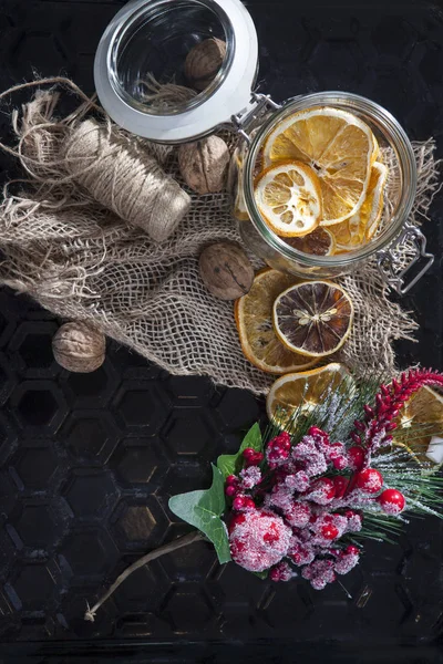 El frasco de vidrio con rodajas de naranja seca con decoraciones navideñas —  Fotos de Stock