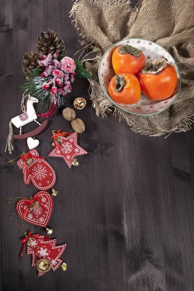 在一张深色木桌上帆布制成的餐巾纸上的柿子 — 图库照片