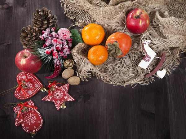 The persimmon in a plate on a napkin made of canvas on a dark wooden table — Stock Photo, Image