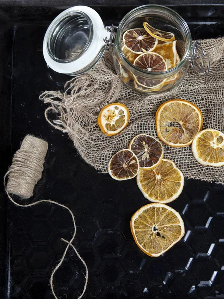 El frasco de vidrio con rodajas de naranja seca con decoraciones navideñas —  Fotos de Stock