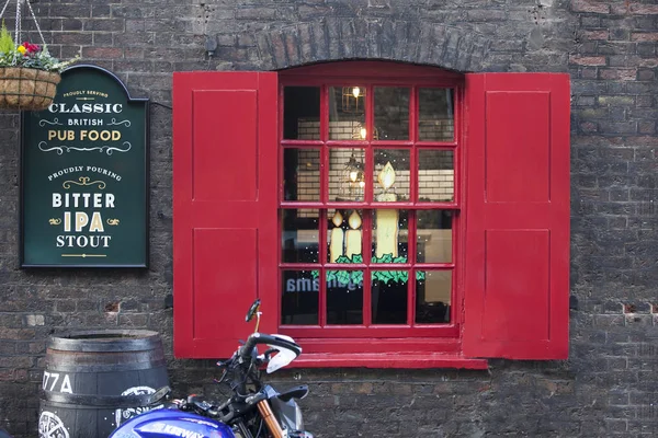 Rode luiken en een pub venster ingericht voor Kerstmis — Stockfoto