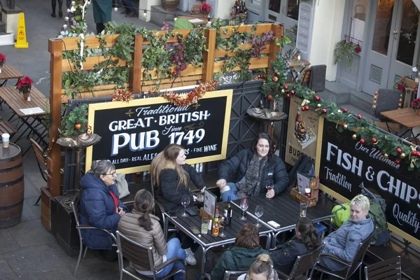 Ett företag av vänner sitter på en pub på Kovet Garden, dricka öl och prata. — Stockfoto