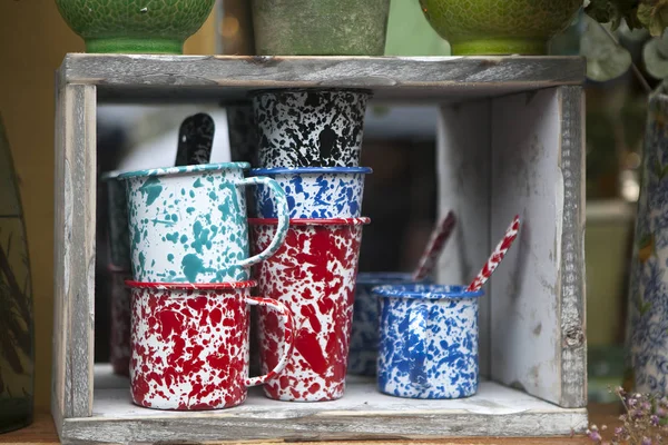 Multicolored cups and glasses on a wooden shelf for sale — Stock Photo, Image
