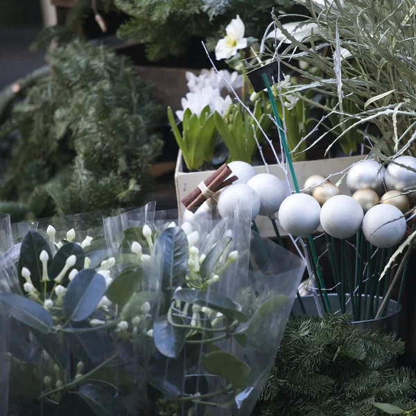 Coronas de abeto, canela y bolas de vidrio como decoraciones se venden en el mercado de flores por Navidad —  Fotos de Stock