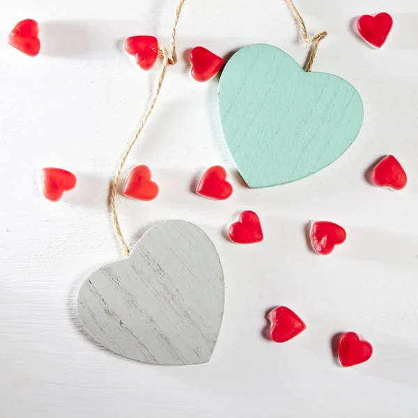 Los corazones de madera, papel y mermelada están en una pared blanca de madera — Foto de Stock