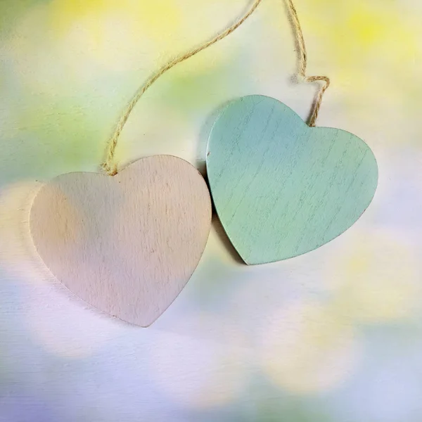 Dos corazones de madera cuelgan de una pared de madera blanca —  Fotos de Stock