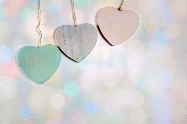 Tres corazones de madera cuelgan de una pared de madera — Foto de Stock