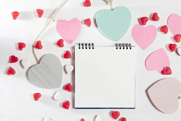 Los corazones de madera, papel y mermelada están en una pared blanca de madera — Foto de Stock