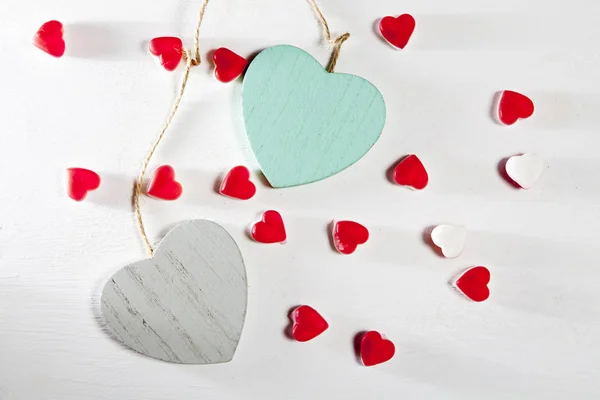 Die Herzen aus Holz, Papier und Marmelade befinden sich an einer weißen Holzwand — Stockfoto