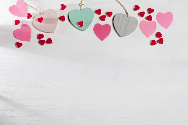 Corazones de madera, papel y mermelada están en una pared blanca de madera — Foto de Stock