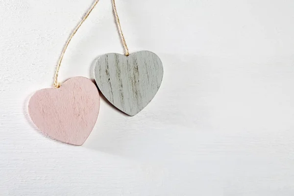 Dvě dřevěné srdce visí na bílé dřevěné stěně — Stock fotografie