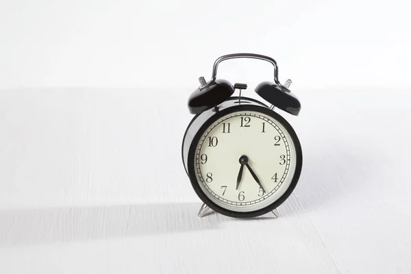 Reloj despertador en mesa de madera blanca — Foto de Stock