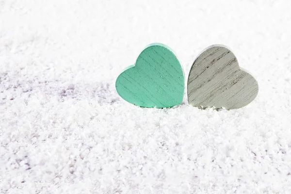 El corazón Dos de madera verde y gris sobre la nieve blanca artificial — Foto de Stock