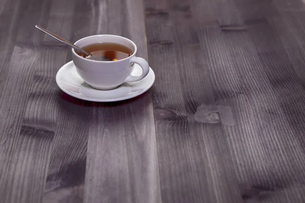 A xícara branca de chá e pires em uma mesa de madeira marrom. Espaço de cópia . — Fotografia de Stock