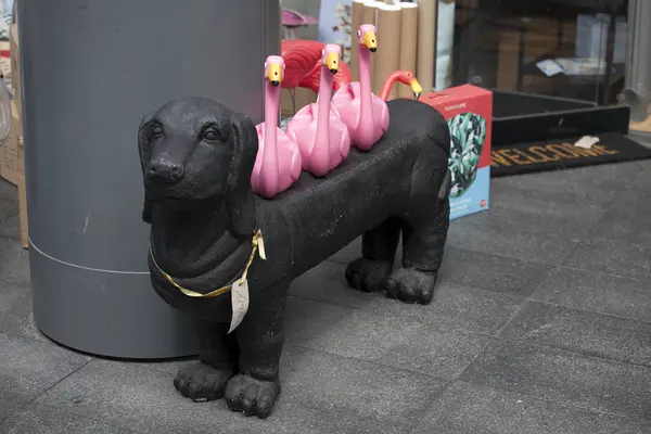 Zwarte kunststof basset hond met roze flamingo's op de achterzijde — Stockfoto