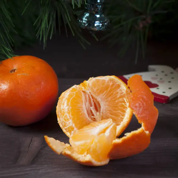 Mezzo mandarino sbucciato si trova su un tavolo di legno — Foto Stock