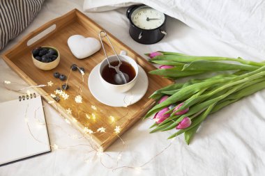 çay ve gingerbread kalp şeklinde ve laleler yatakta bir buket