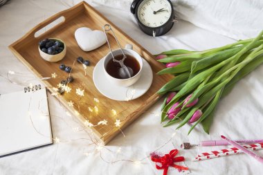 çay ve gingerbread kalp şeklinde ve laleler yatakta bir buket