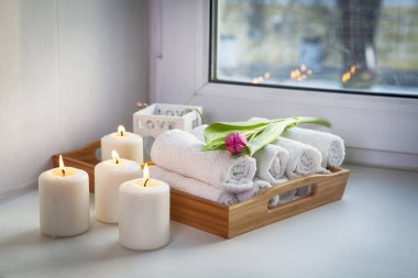 bir tepsi yanan mumlar ve Lale spa salonda bir buket yanında çekilmiş el havlusu