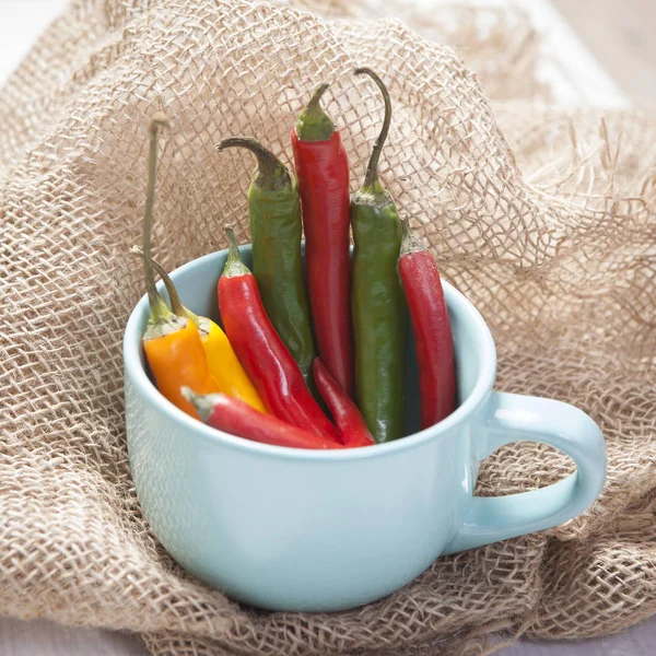 The Hot pepper in the blue mug on the canvas — Stock Photo, Image