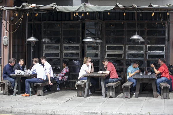 Menschen essen Mittagessen in einem stilvollen Straßencafé in East London, in der Nähe der Backsteingasse — Stockfoto
