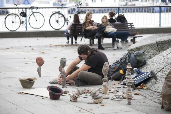 Man makes sculptures of stones on the waterfront — Stock Photo, Image