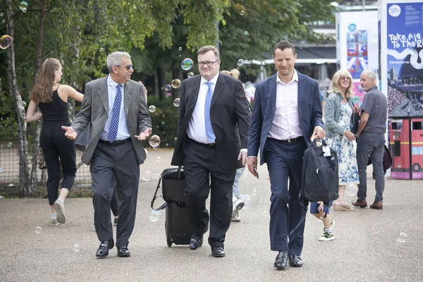 Businessmen with suitcases are walking along South bank — Stock Photo, Image