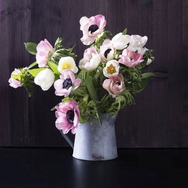 Bukiet ślubny, zawilce i tulipany z ruszczyka w dzbanku na czarnym tle — Zdjęcie stockowe