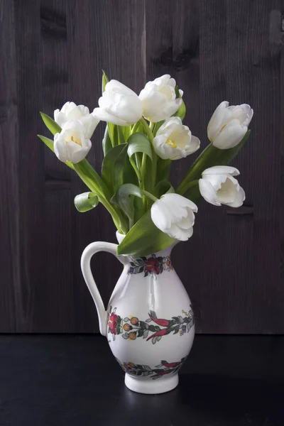 Hochzeitsstrauß aus Tulpen mit Zwieback in einem Krug auf schwarzem Hintergrund — Stockfoto