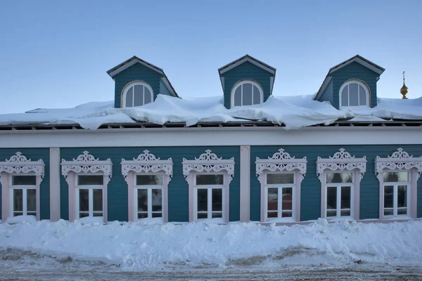 Houten geschilderde gesneden poorten in Arts nouveau bedekt met sneeuw gevel van een houten huis. Decoratief houtsnijwerk. Russische folk stijl — Stockfoto