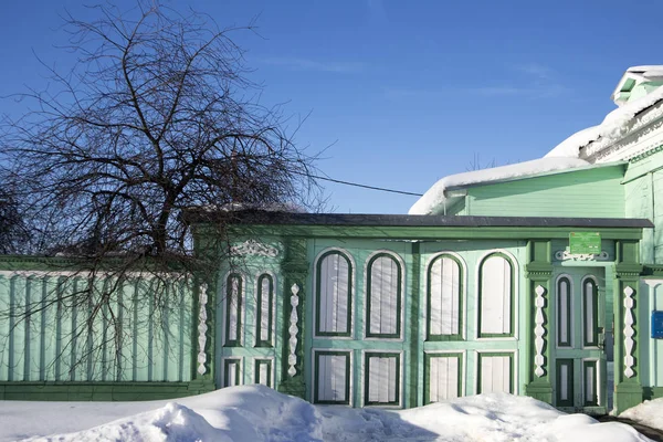 Portas esculpidas pintadas de madeira nas artes nouveau coberto com neve. Fachada de uma casa de madeira. Escultura em madeira decorativa. Estilo popular russo — Fotografia de Stock