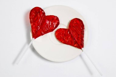 Kalp şekli onwhite arka planda kırmızı lolipop şeker.