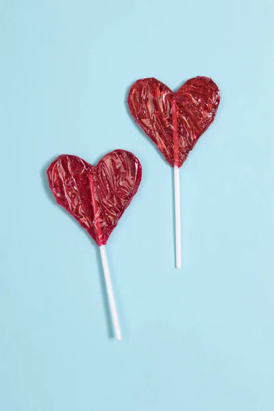 the red Lollipop candy in heart shape on dark blue background.