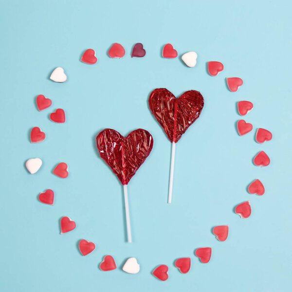 the red Lollipop candy in heart shape on dark blue background.