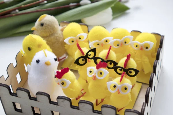 The Fluffy yellow rag chicken with glasses in a wooden basket as a decoration of a table for Easter — Stock Photo, Image