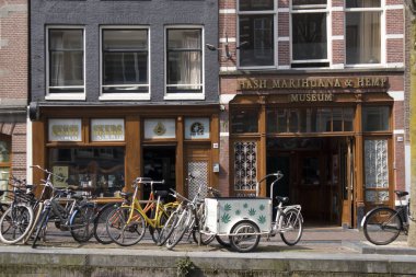 Kanal boyunca tipik eski Amsterdam binalar. Banklar insanlar. Lale Küvetler