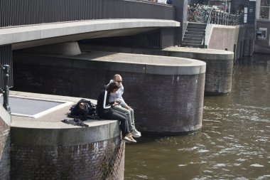 Hemen bacaklarını açıp Amstel asılı bir köprü, mutlu bir çift oturur